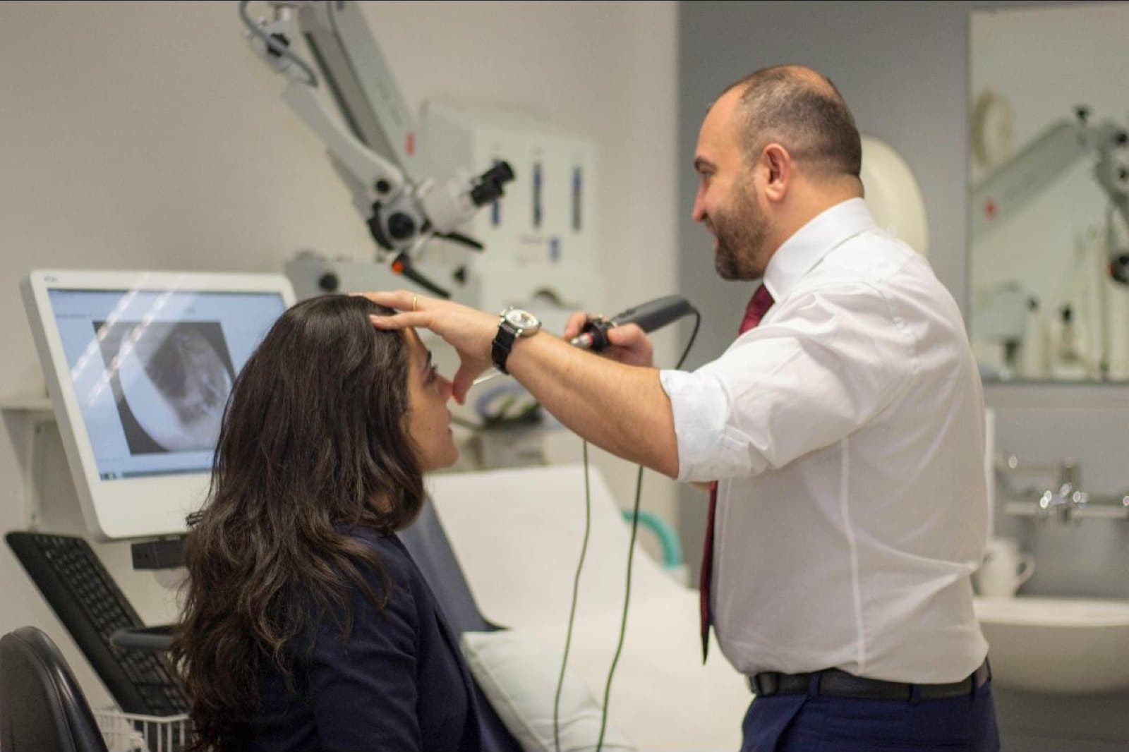 Mr Anwar assessing a patient's nasal airway with an endoscope in clinic