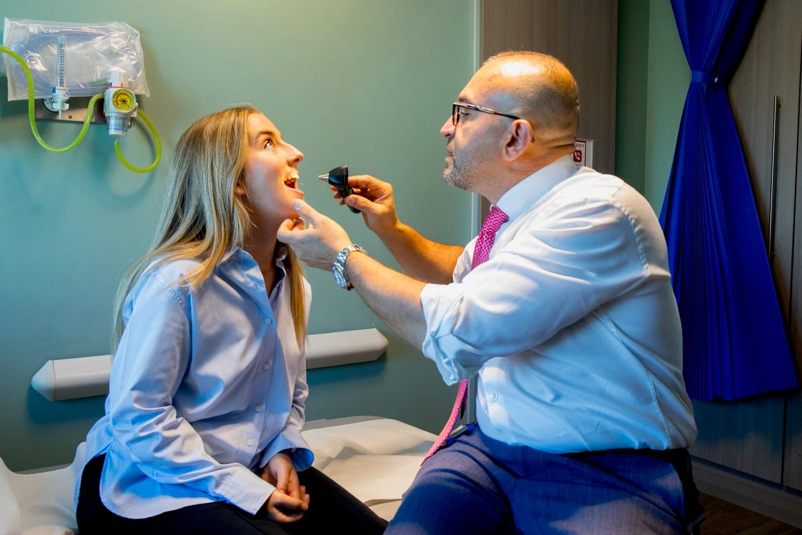 Mr Anwar examining a patient's throat in clinic